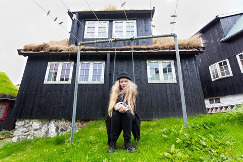 Faroe Island girl swinging on swing