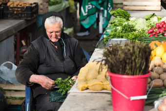 Old Croatian lady selling vegetables at market in Split, Croatia