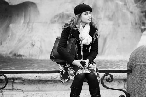 italian young woman sitting on rail of fountain in rome